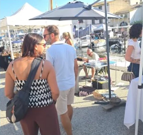 Visiteurs devant les stands le long du port