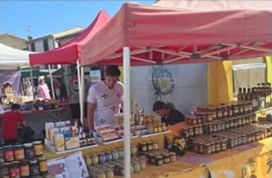 Stand de producteur de miel sous un barnum rouge